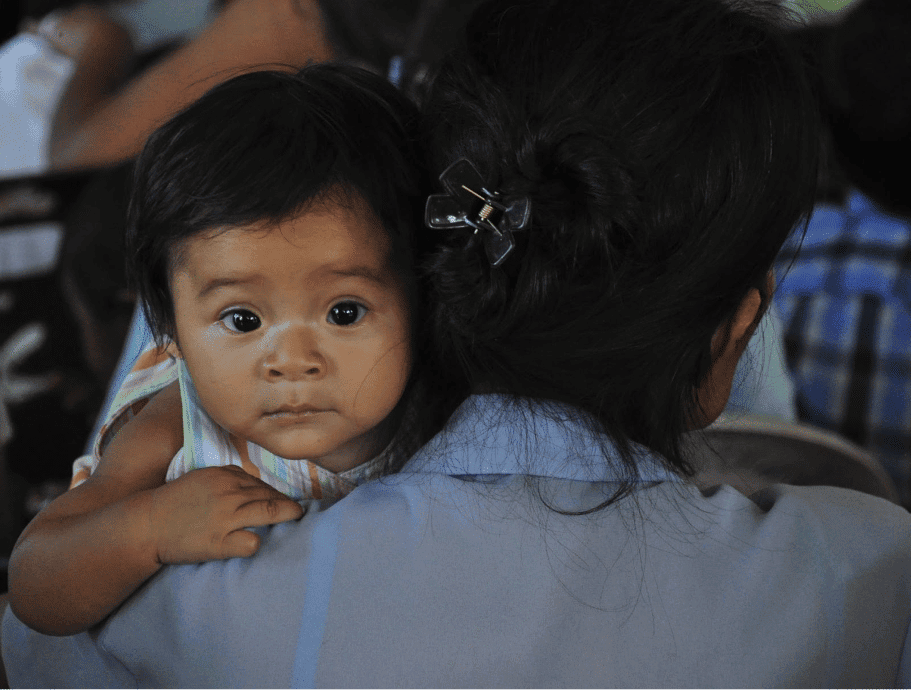 Baby looking at the camera over a woman's shoulder